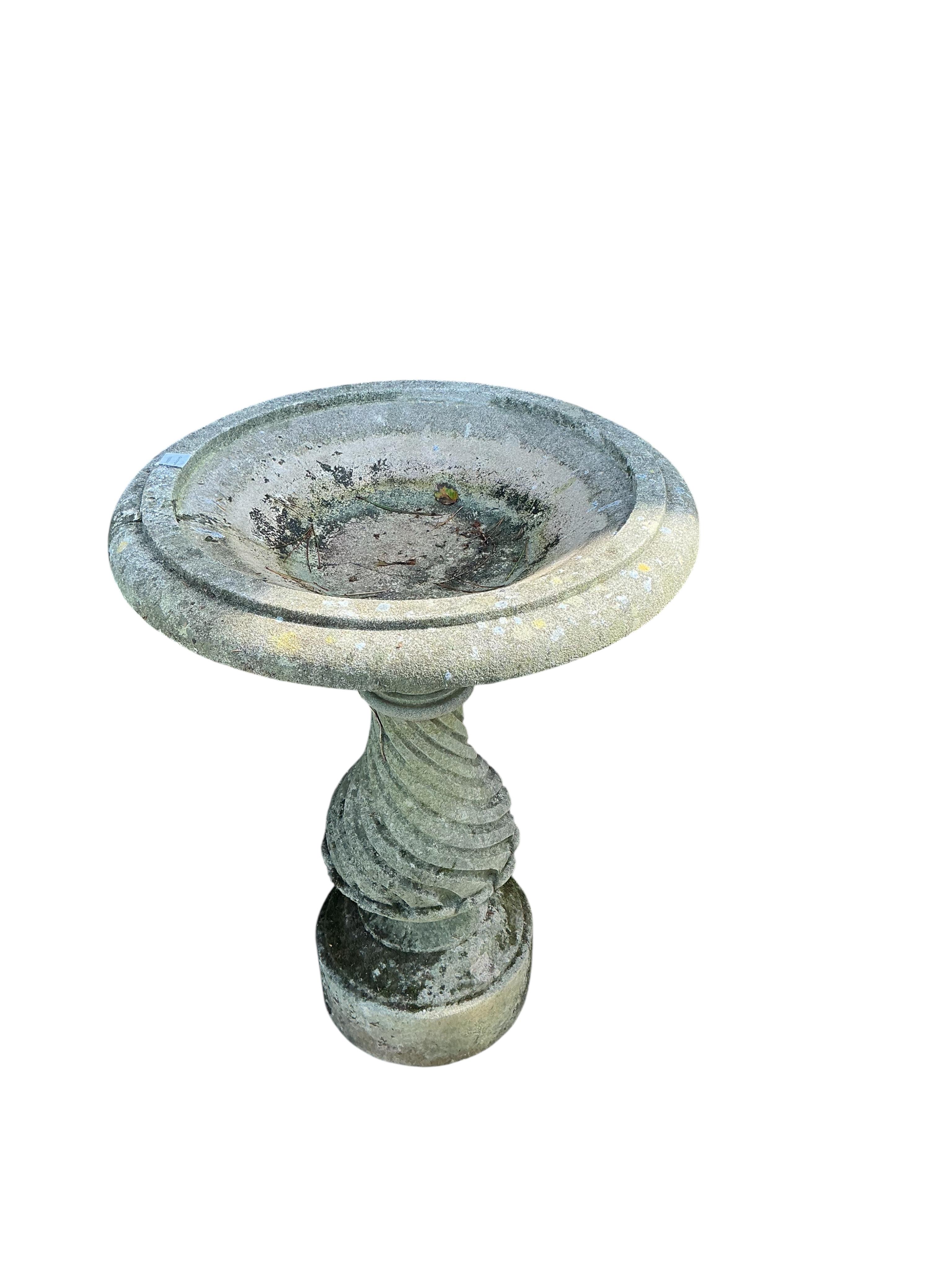 A circular reconstituted stone birdbath, diameter 68cm, height 92cm